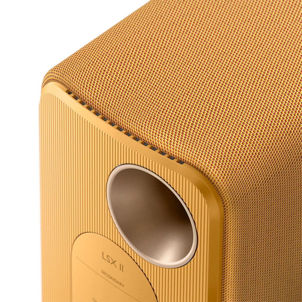Close-up of a gold-colored speaker with 'LSX II' branding on a white background