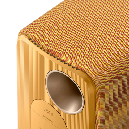 Close-up of a gold-colored speaker with 'LSX II' branding on a white background