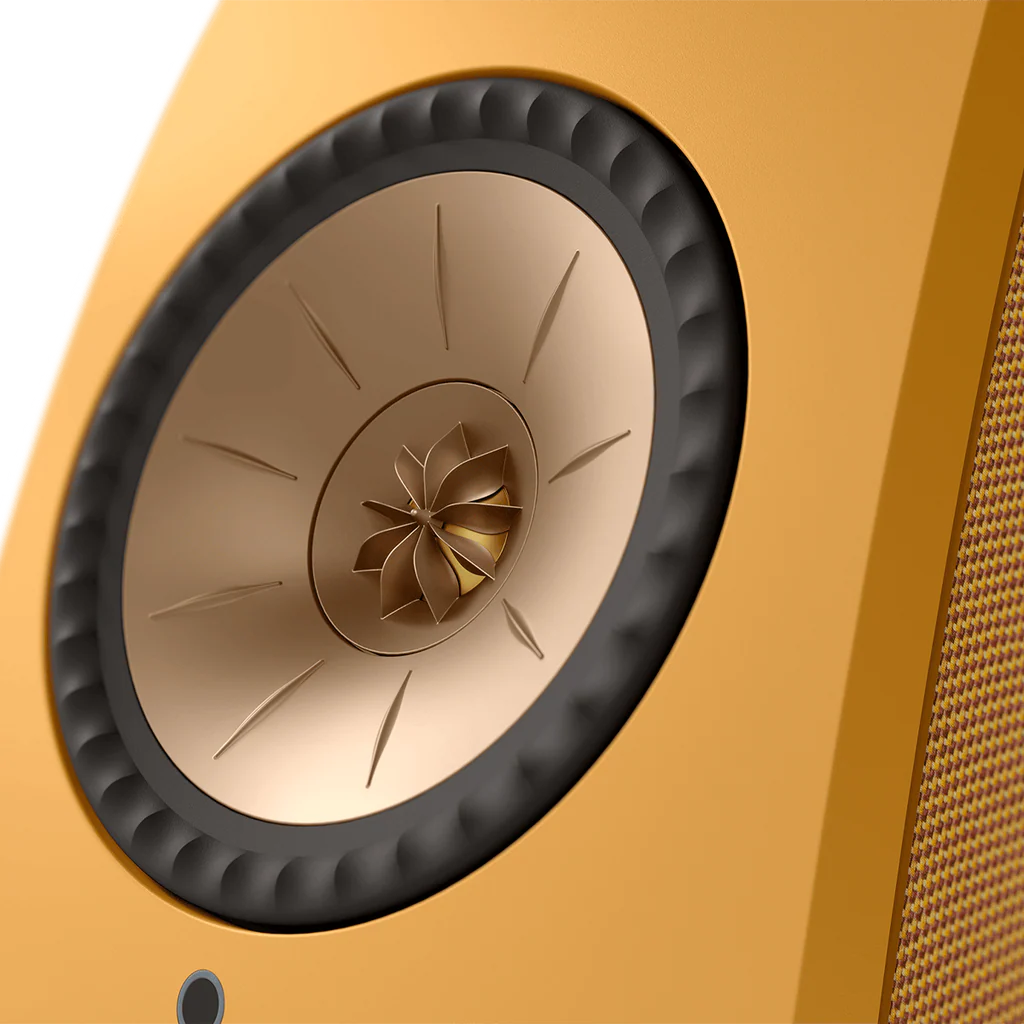 Close-up of a speaker cone on a yellow background